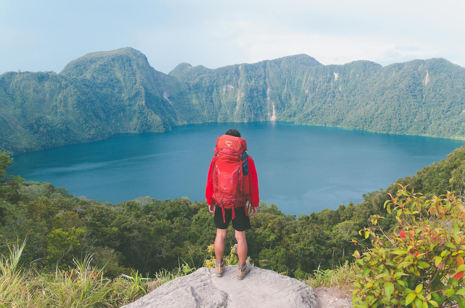 a man wearing shorts facing a lake