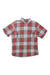 The Filson Men's Alaskan Guide Shirt is a short-sleeved, button-up outdoor shirt featuring red, white, and blue plaid and two chest pockets, inspired by rugged classic designs.