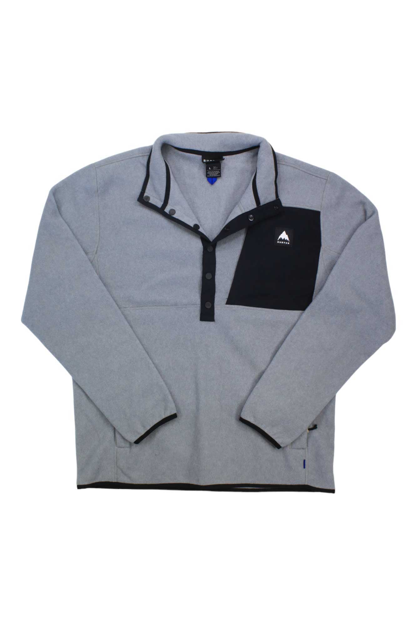 The Burton Mens Cinder Fleece Pullover is a light grey, relaxed-fit top made from soft recycled polar fleece, featuring a black snap-button placket, a black chest pocket with a white mountain logo, and a slightly raised collar for comfort.