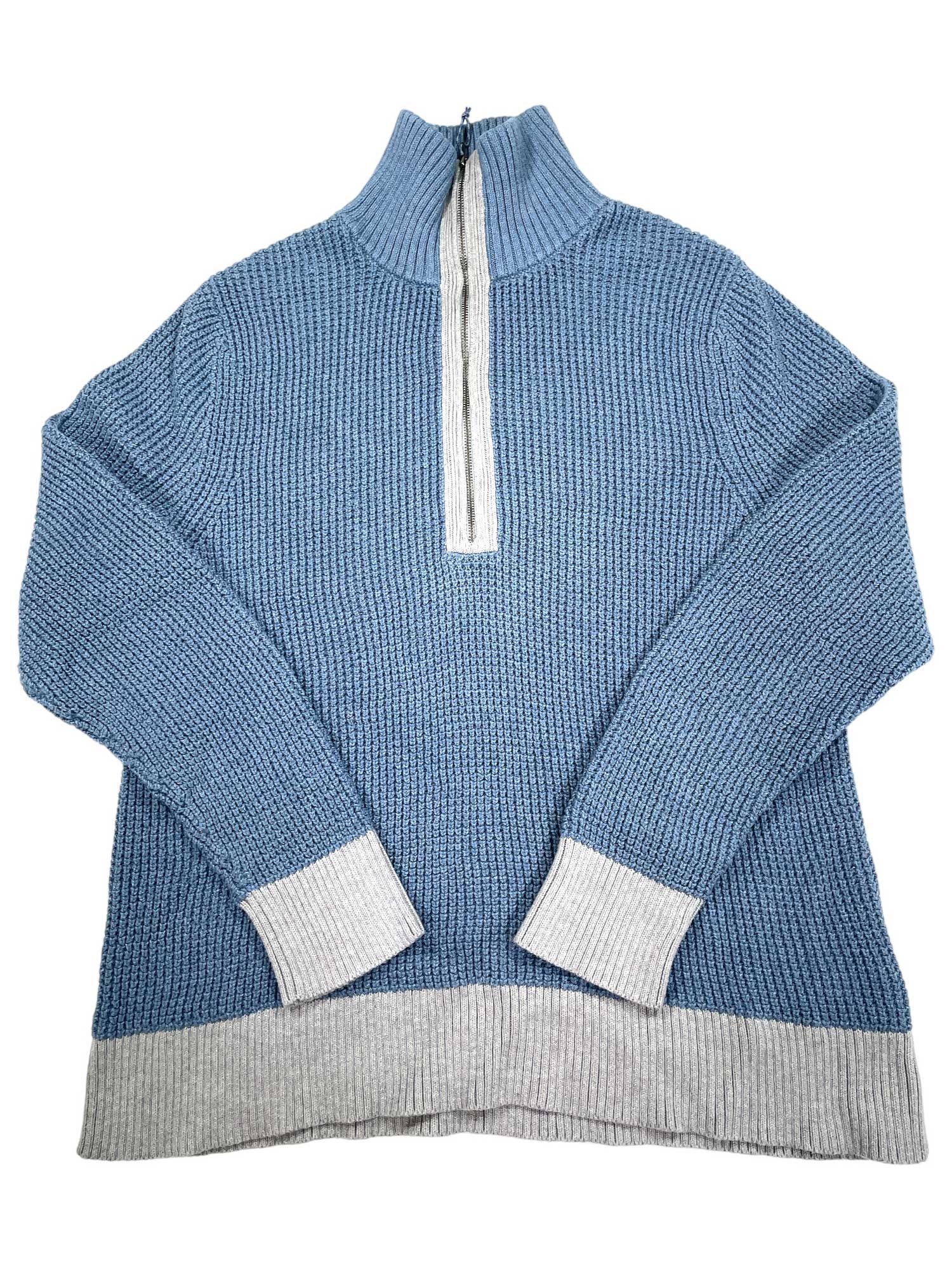 The Glacier 1/4 Zip Fleece is a blue women's sweater featuring a high collar, half-zip front, and light gray ribbed cuffs and hem.