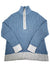 The Glacier 1/4 Zip Fleece is a blue women's sweater featuring a high collar, half-zip front, and light gray ribbed cuffs and hem.