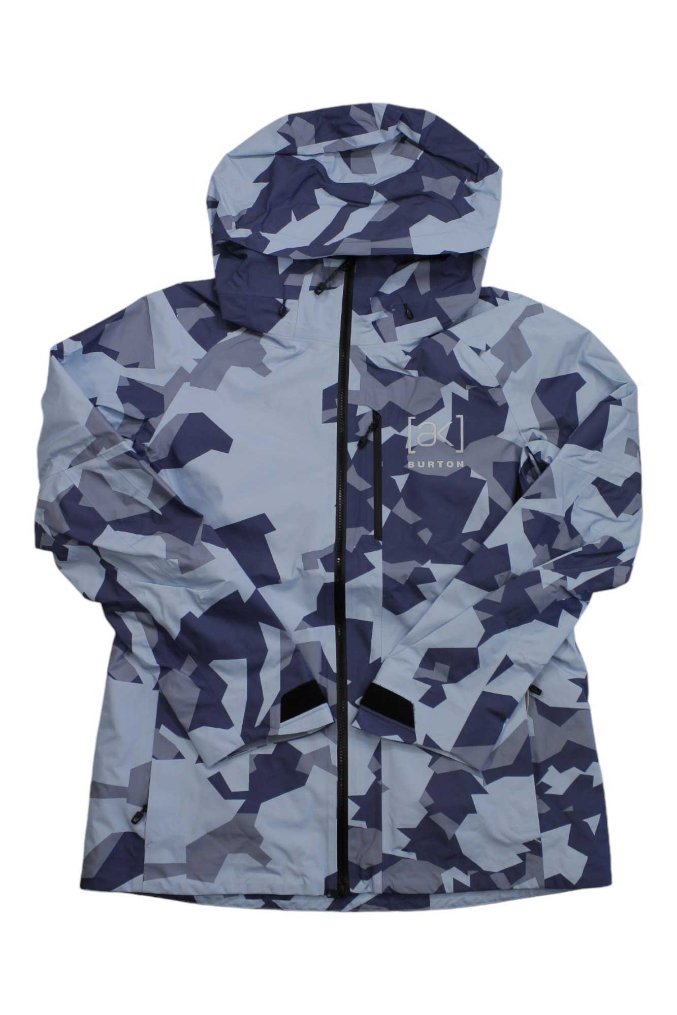 The Burton Women's AK GTX Upshift Jacket is a waterproof jacket with a blue, gray, and white geometric camo pattern, hood, front zipper, and Burton logo on the left chest.