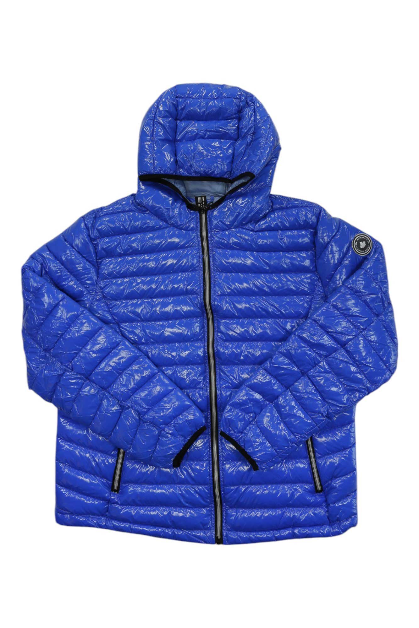 The NOIZE Men's Finnigan Jacket is a bright blue puff jacket with recycled fill insulation, a hood, black zipper and trim on pockets and cuffs, plus a round logo patch on the left sleeve. It is shown laid flat against a white background.