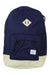 The Herschel Supply Company Heritage Backpack is navy blue with beige accents, a front pocket, a white rectangular logo patch near the base, a beige diamond patch at the top, and is laptop compatible.