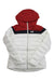 The Helly Hansen Womens Imperial Puffy Jacket is waterproof, features synthetic down insulation, a white body with red hood and shoulders, black chest stripe, front zipper, and HH logo on the left chest.