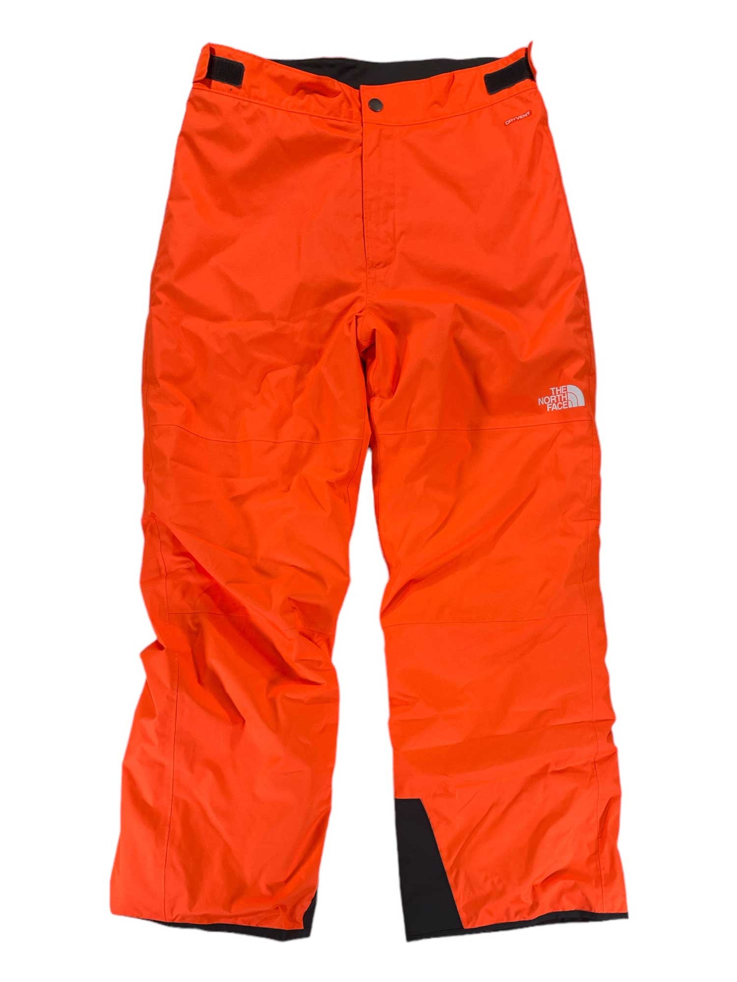 Bright orange Kids' Freedom Insulated Snow Pants by The North Face, featuring waterproof fabric, button and Velcro closure, adjustable waist tabs, black reinforced cuffs, and a white logo on the upper left thigh. Laid flat on a white background.