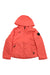 The Obermeyer Girls Rylee Jacket in bright coral pink features a front zipper, two zippered side pockets, and a black circular patch on the upper left sleeve—ideal as a girls’ ski or outdoor jacket.