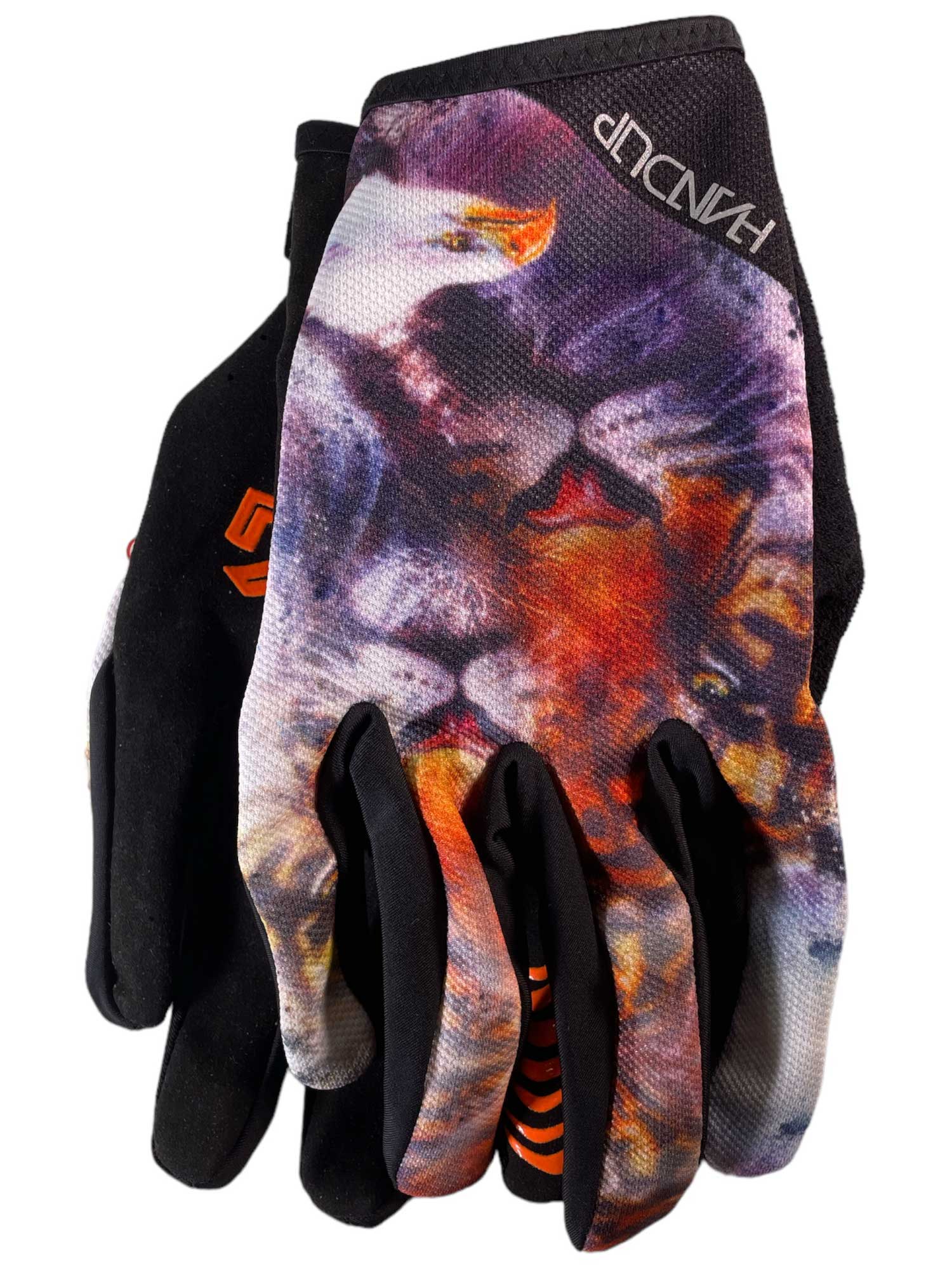 The Handup Glove is a mostly black mountain biking glove with realistic eagle and lion prints, orange finger accents, and touchscreen compatibility for convenience.