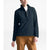 A person wears a black North Face Women's Mountain Sweatshirt 3.0 Pullover over a white shirt with tan pants, standing against a white background. Their head is slightly tilted, and their right hand rests relaxed by their side.
