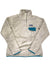 The Women's Re-Tool Snap-T Pullover is a light gray Polartec Thermal Pro fleece with a high collar, blue-trimmed chest pocket and edges, Patagonia logo on the pocket, and is Fair Trade Certified.