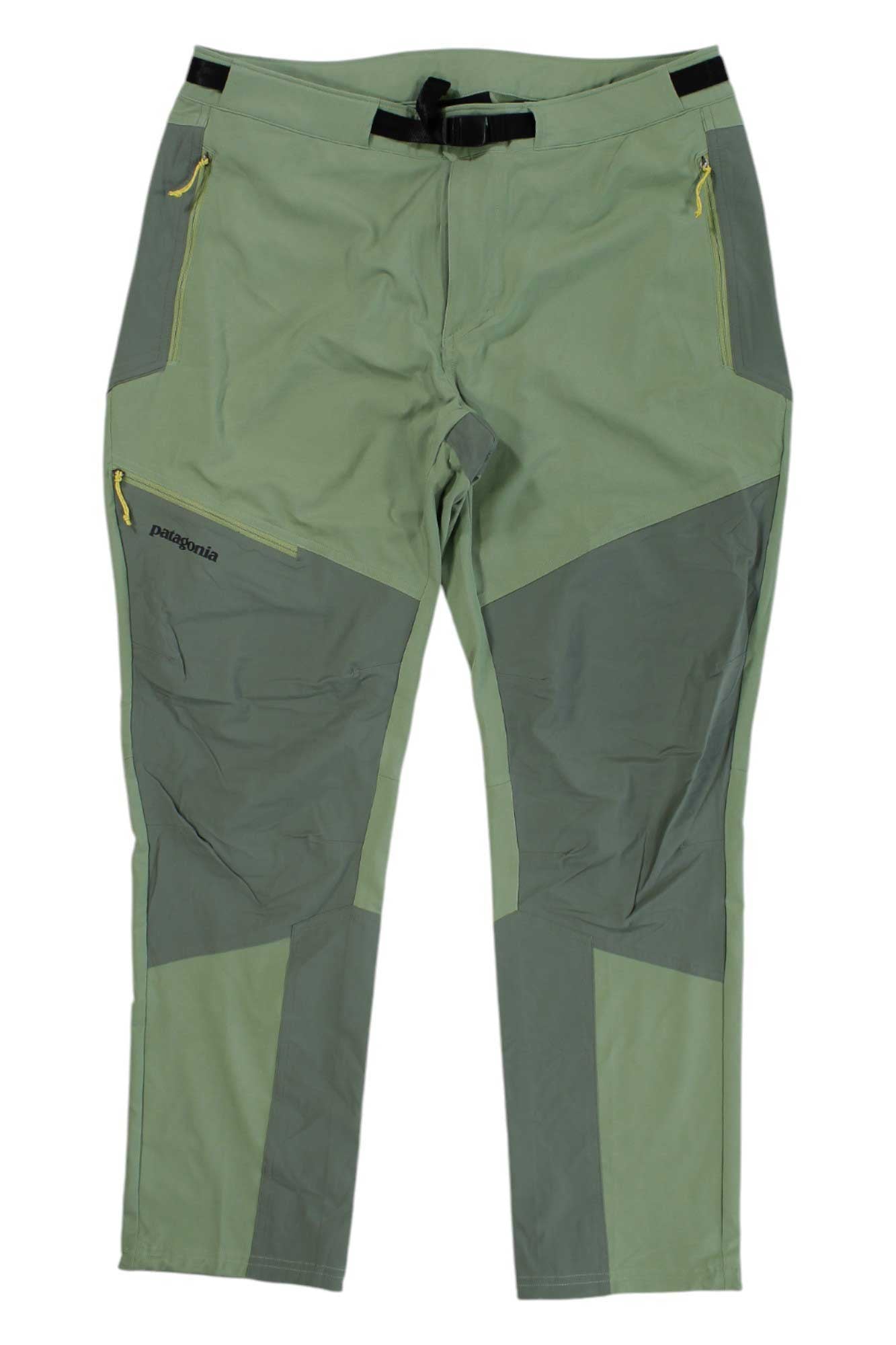 The Womens Altvia Alpine Pants - Short feature a light green color with darker green reinforced knee/thigh panels, a black adjustable belt, yellow zipper accents on the front pockets, and the Patagonia logo near the left pocket.