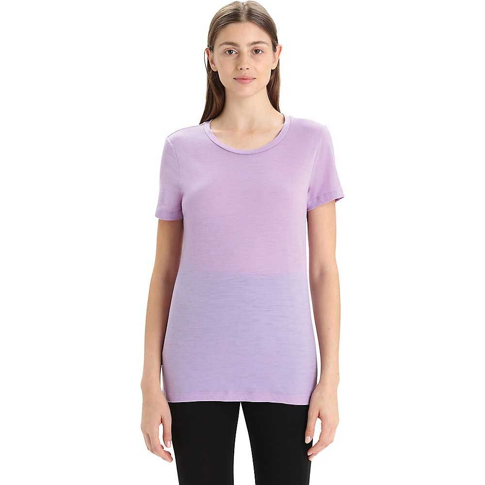 A woman stands facing forward in an Icebreaker Womens Tech Lite II SS Tee (lavender) and black pants, against a plain white background.