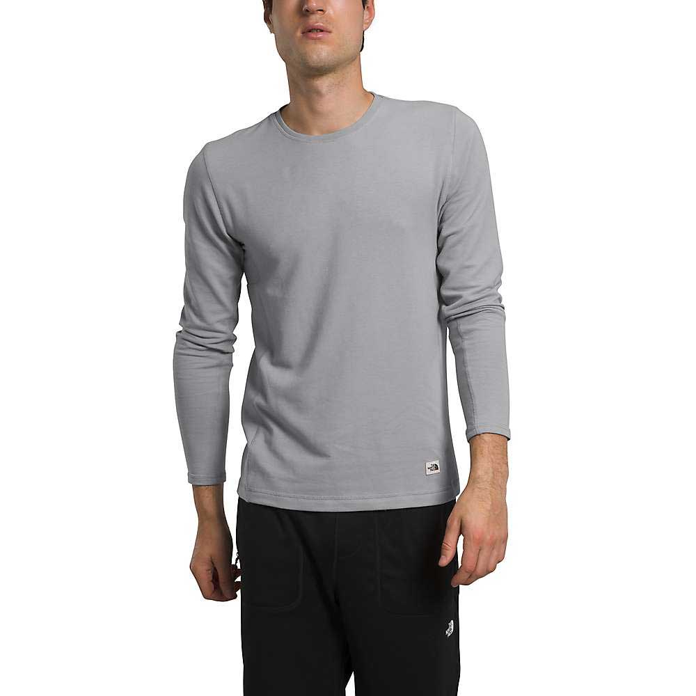 A man wearing The North Face Men's Terry Crew in light gray and black pants stands against a white background.