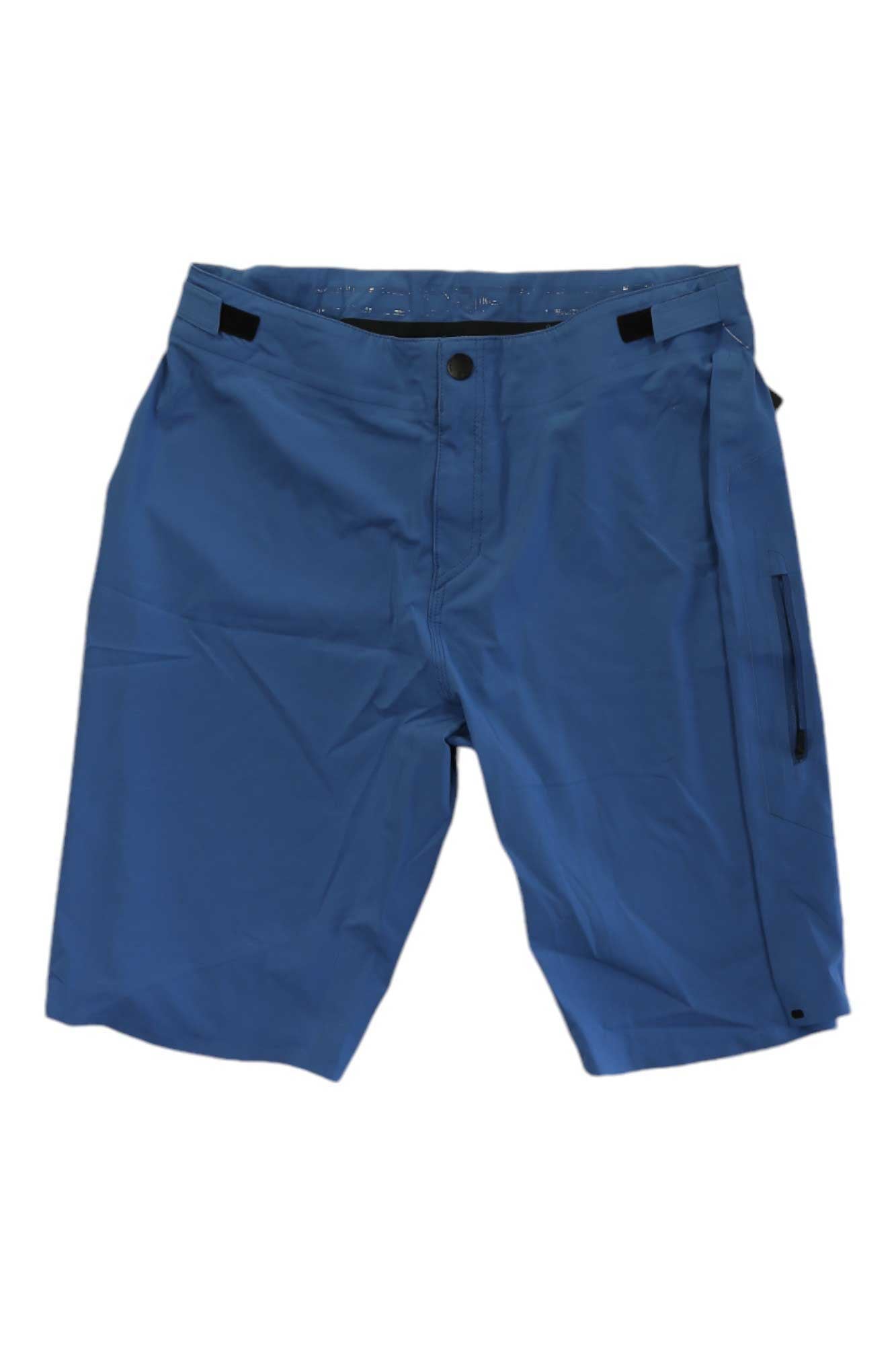 Troy Lee Designs Mens Drift Short Shell in blue features 4-way stretch, button and zipper closure, belt loops, and a zippered right leg pocket, shown knee-length against a white background.
