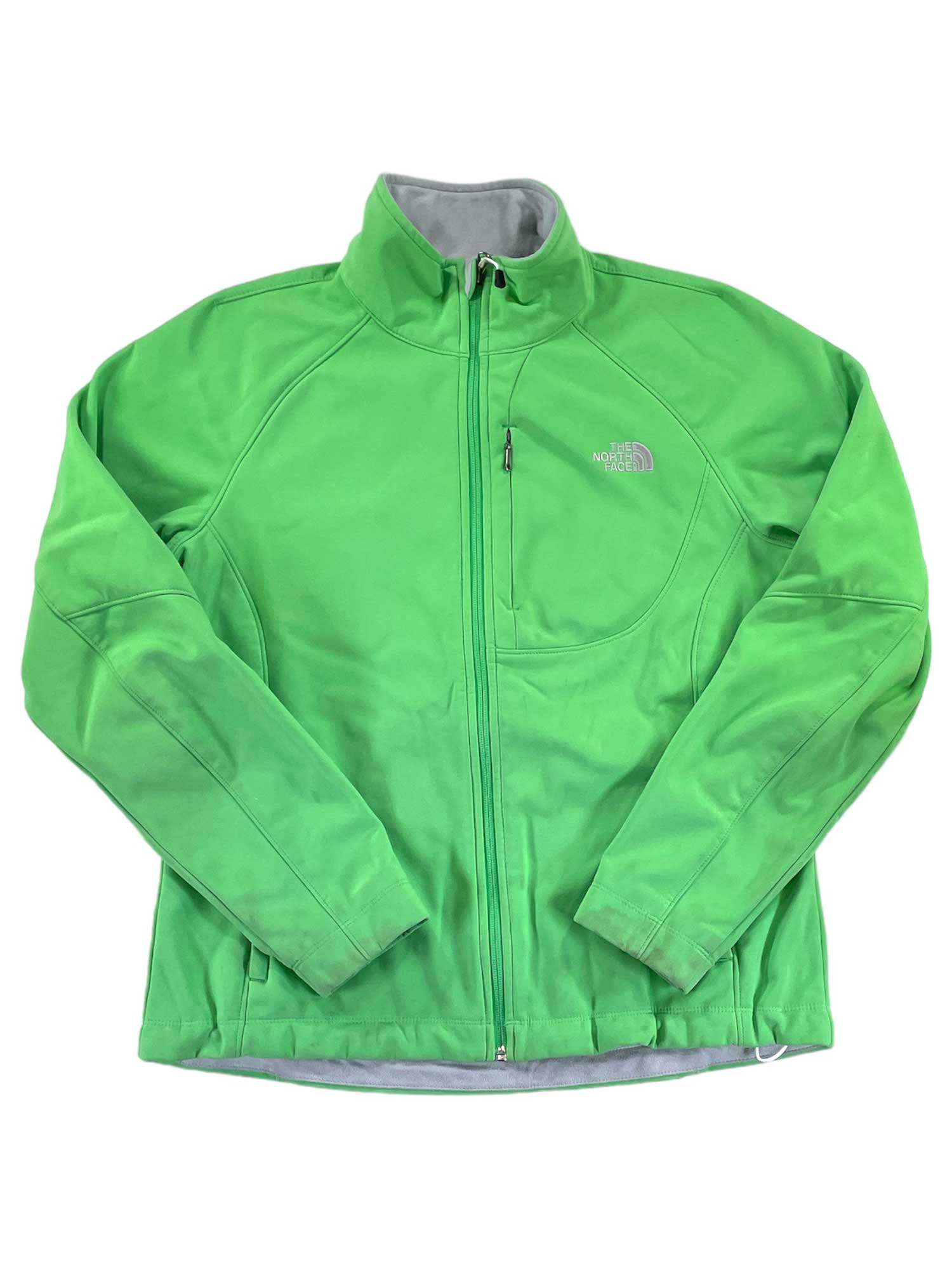 The North Face Womens Apex Bionic Soft-Shell Jacket in bright green features long sleeves, a high collar, side pockets, and a visible logo on the left chest. The windproof jacket is laid flat on a white background.