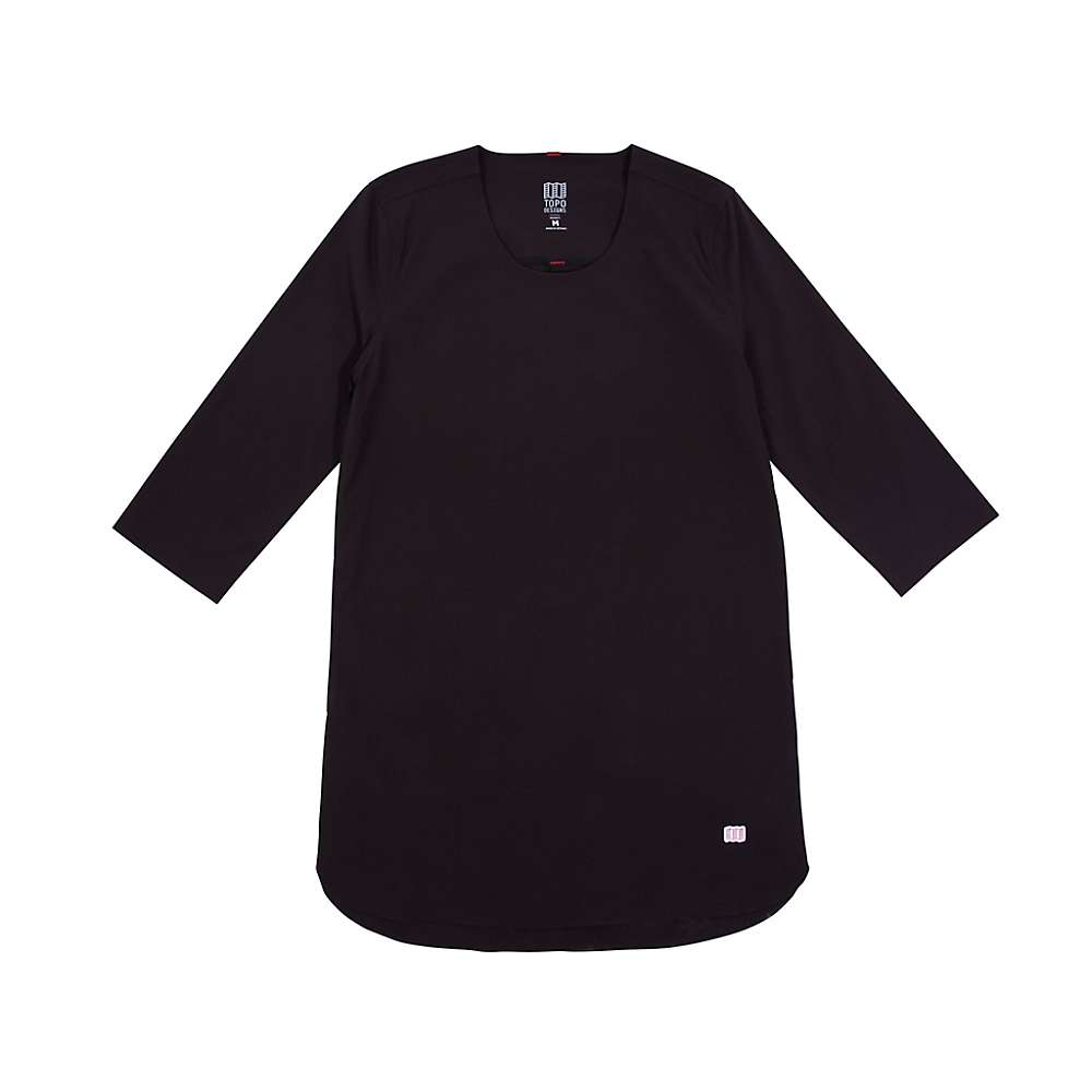 The Topo Designs Women's Global Pullover Top in black, shown laid flat on a white background, features three-quarter sleeves, a round neckline, knee-length cut, and a small white logo near the hem for subtle branding.