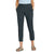 A person in Sherpa Women's Sajilo Ankle Pant - Black XL, a light blue patterned shirt, and tan sandals stands with hands in pockets against a plain white background.