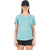 A woman faces forward, wearing a black cap, black shorts, and the Mons Royale Women's Zephyr Tee in Sage (size XS), an eco-friendly light blue shirt with a small graphic near the left shoulder. The background is plain white.