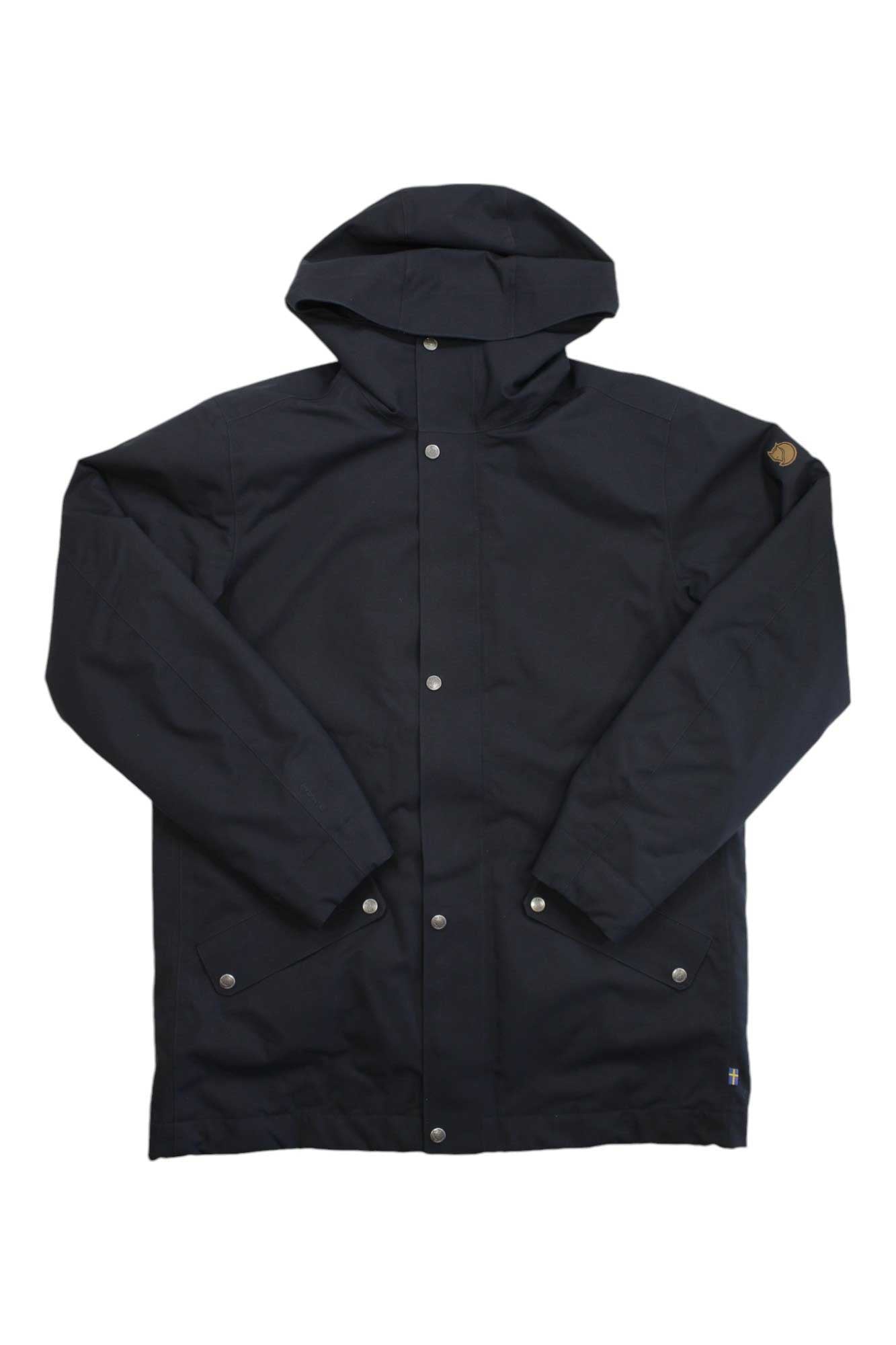 The Fjallraven Mens Visby 3 in 1 Jacket is black with snap buttons, long sleeves, two front flap pockets, and a small round patch on the upper left sleeve. Made from recycled polyester, it's shown flat against a white background.