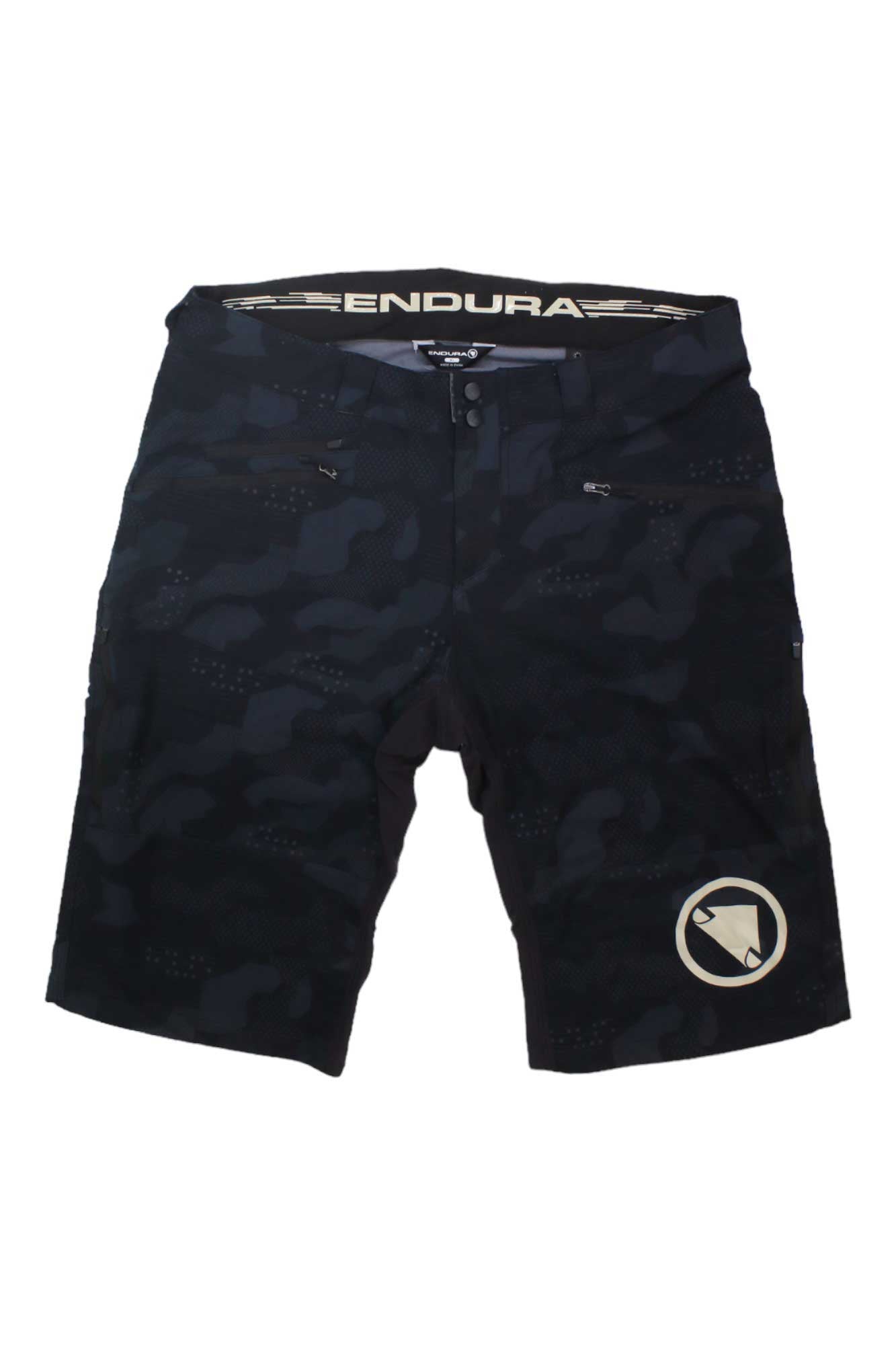 The Endura Mens SingleTrack II Short features a black camo design, zippered pockets, and a circular logo on the lower left leg—perfect men's mountain bike shorts.
