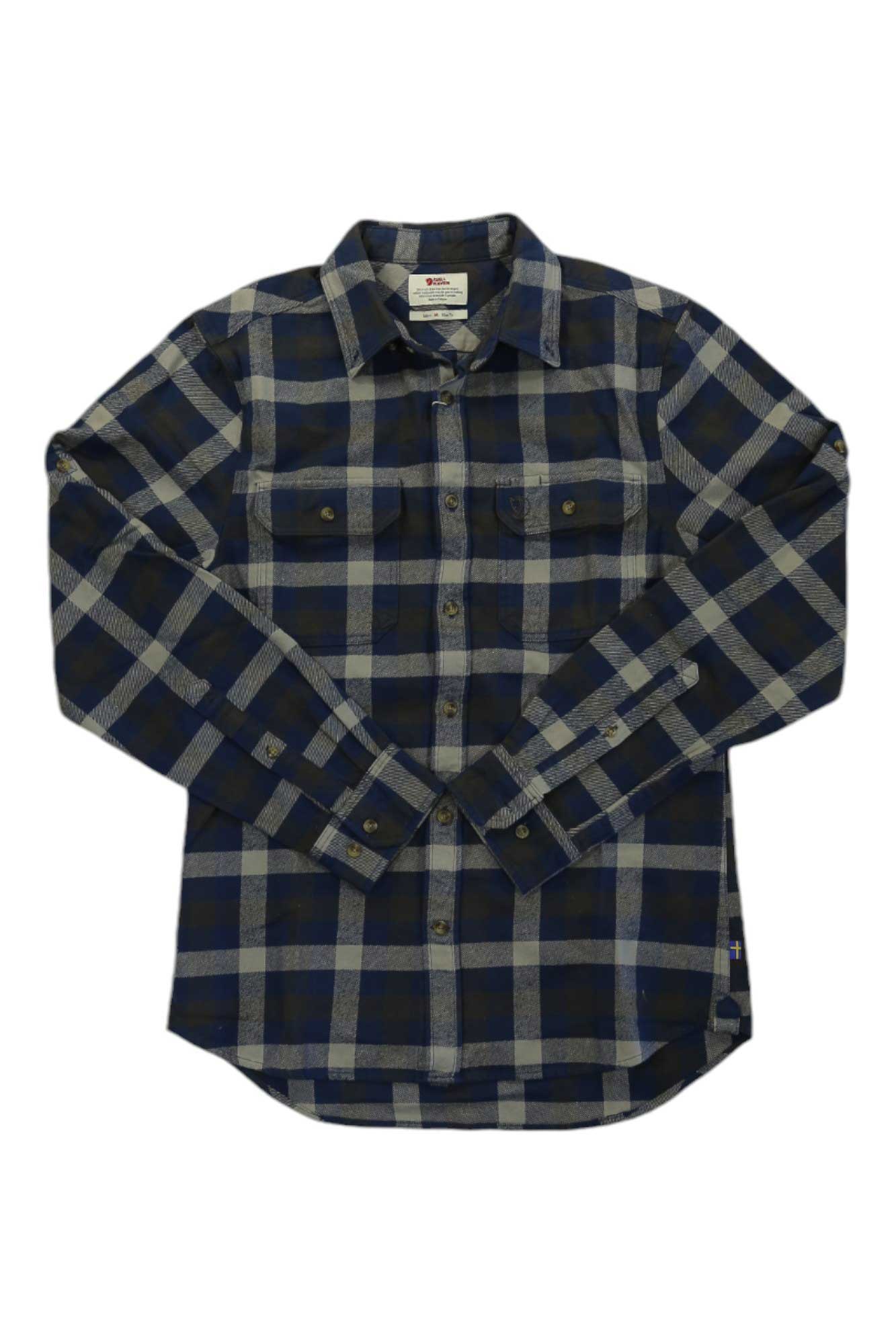 The Fjallraven Mens Skog Shirt is a long-sleeved, slim fit heavy cotton flannel with a blue and gray plaid pattern, two chest pockets, and buttoned cuffs, shown laid flat on a white background.