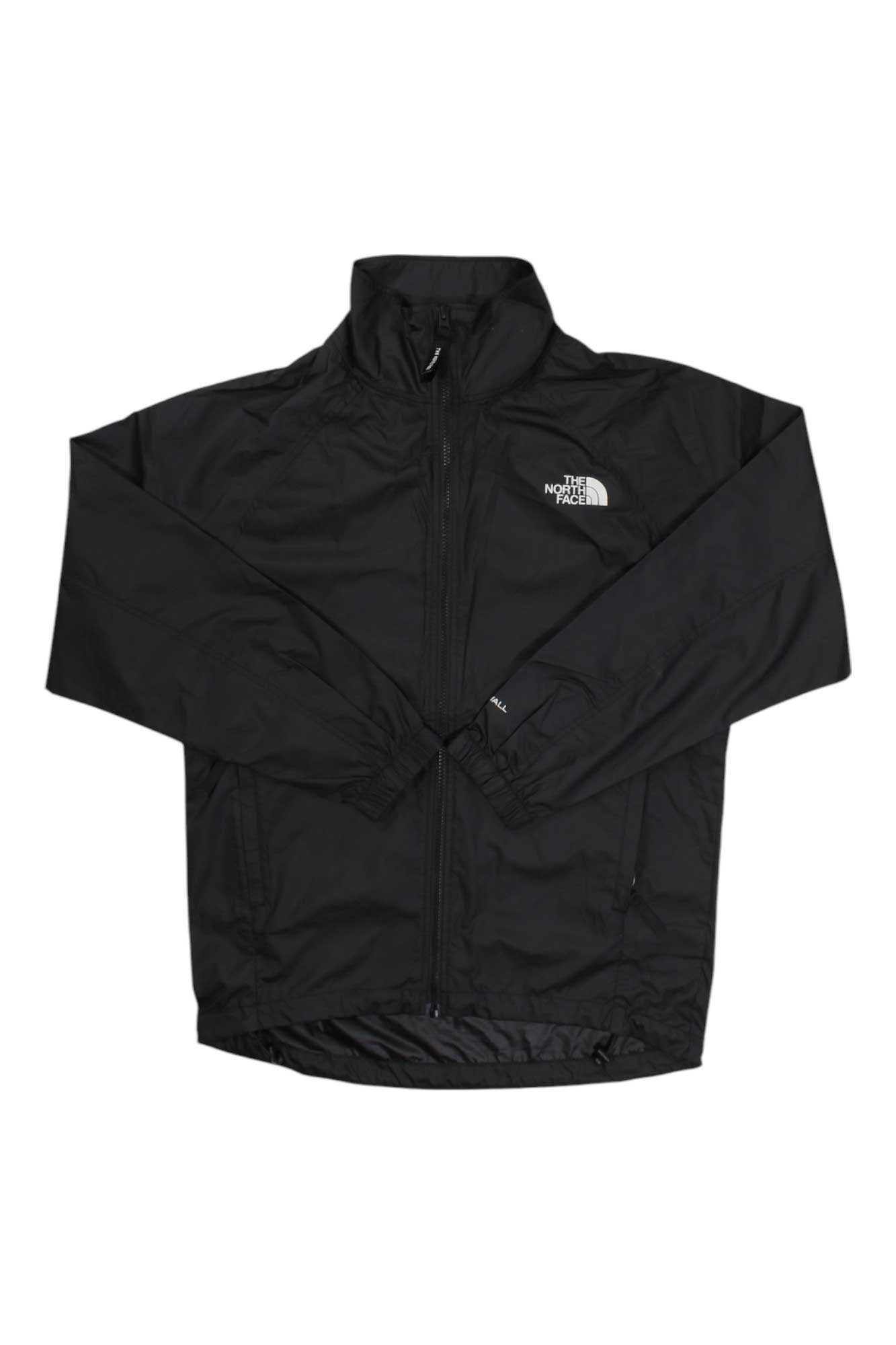 The North Face Womens NSE Graphic Wind Jacket in black features a front zipper, high collar, long sleeves, and a white logo on the left chest. Lightweight and wind-resistant, it's ideal for outdoor activities.