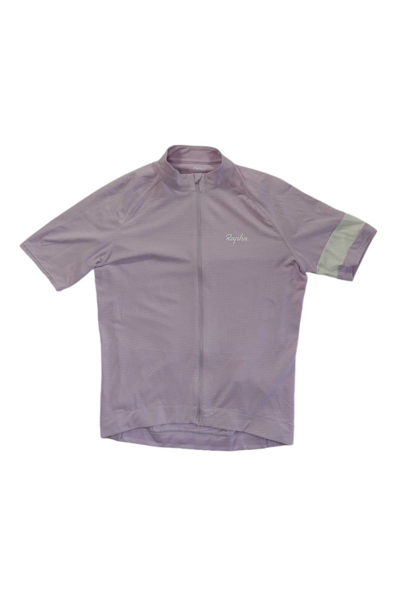 The Rapha Mens Core Lightweight Jersey is a light purple, short-sleeve cycling top with a front zipper, subtle chest logo, and pale green left sleeve stripe—ideal for lightweight, breathable comfort on rides.