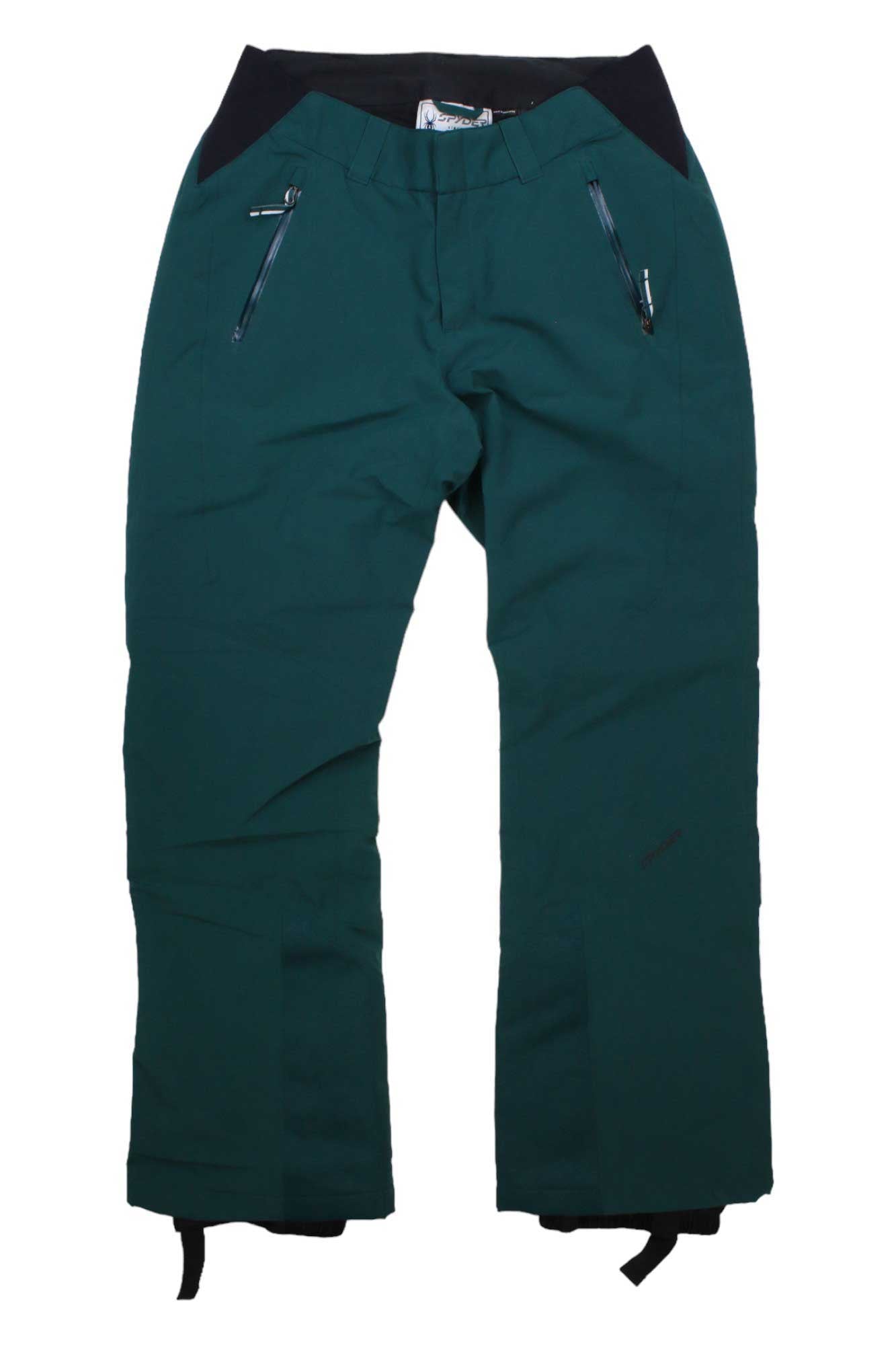 The Spyder Womens Winner Pant in green features a black waistband, zipper pockets, reinforced knees, waterproof fabric, and PrimaLoft insulation. The pants are laid flat on a white background.