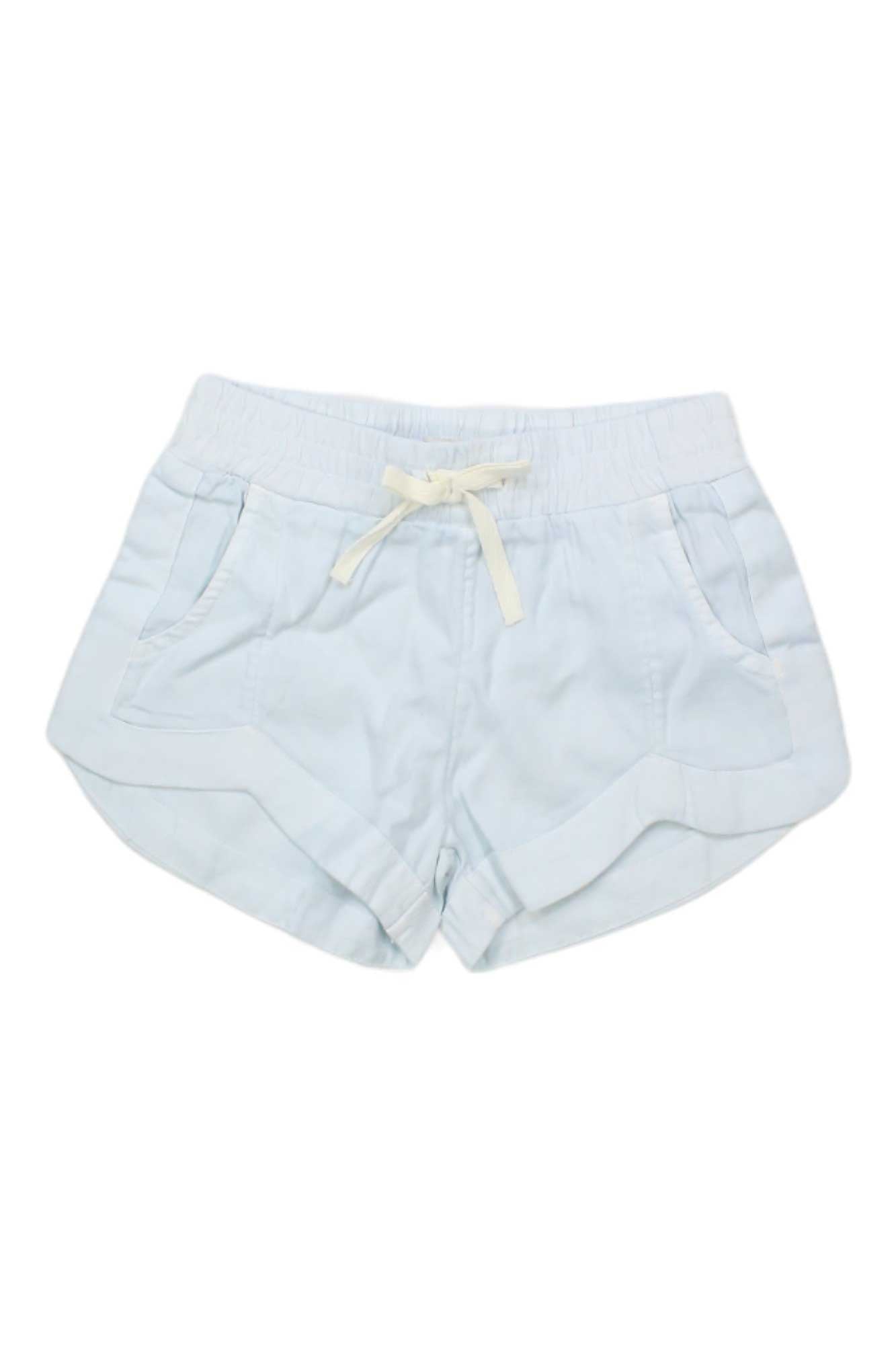 The Billabong Girls Mad For You Short in light blue features soft viscose crinkle fabric, an elastic waistband with white drawstring, side pockets, and curved hems, shown flat on a white background.