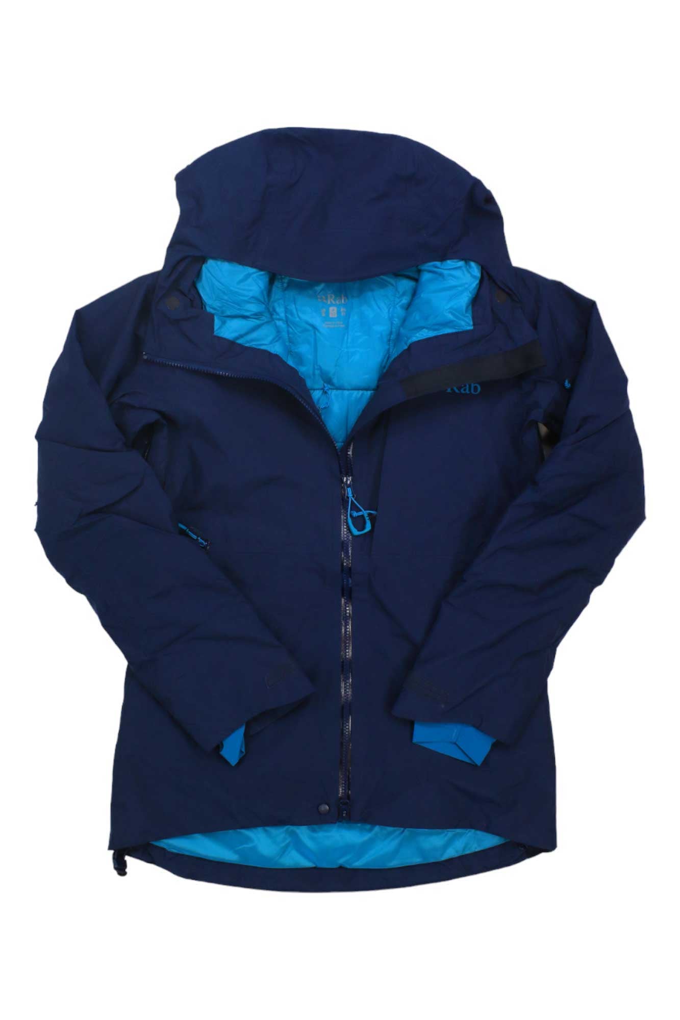 The Rab Women's Khroma Volition Jacket is a navy blue GORE-TEX hooded jacket with a light blue lining, front zipper, and two zippered pockets. The waterproof jacket is shown laid flat, sleeves slightly bent inward.