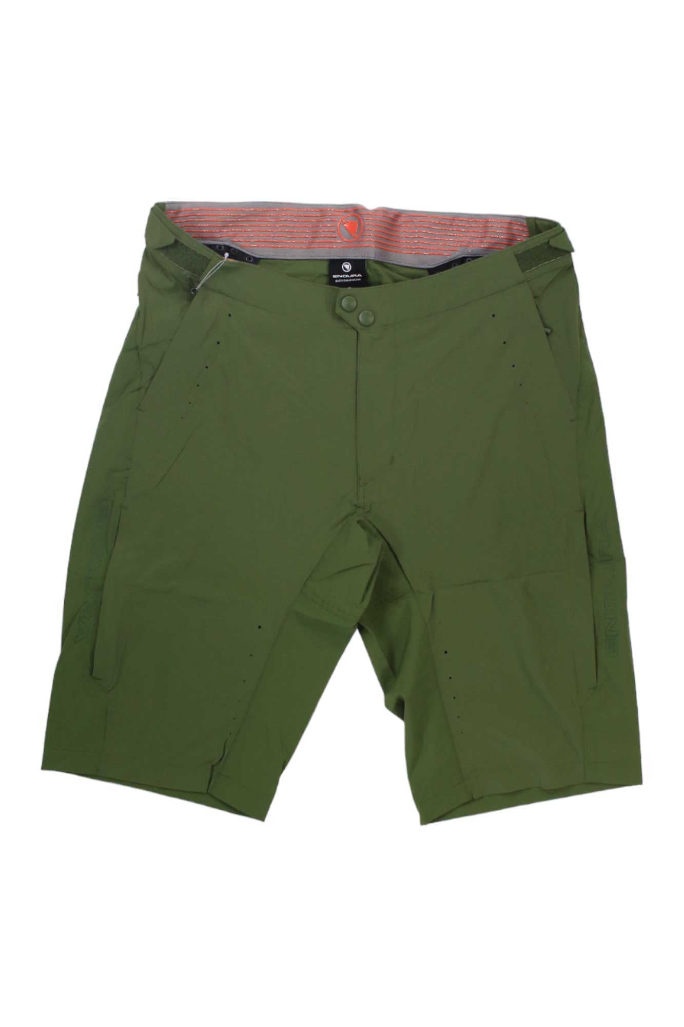The Endura Mens GV500 Foyle Short is an olive green, knee-length pair of lightweight woven shorts with side pockets, button and zip closure, and a red-striped inner waistband, shown laid flat on a white background.