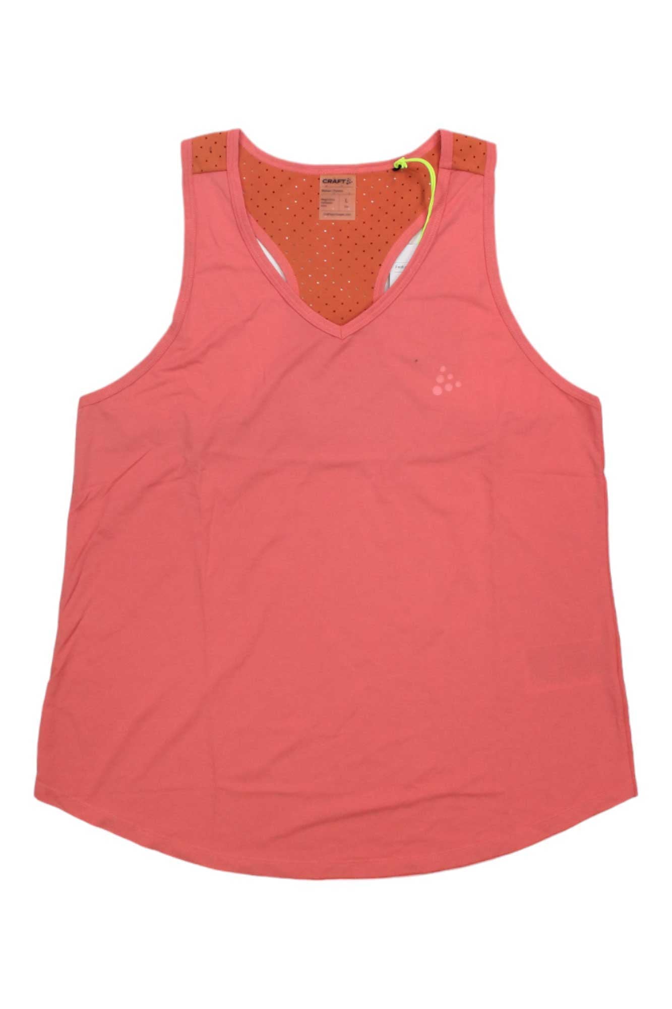 The Craft Sportswear Womens Adv Charge Perforated Singlet is a coral pink sleeveless athletic tank with a scoop neckline and mesh back, combining comfort and style for any workout.