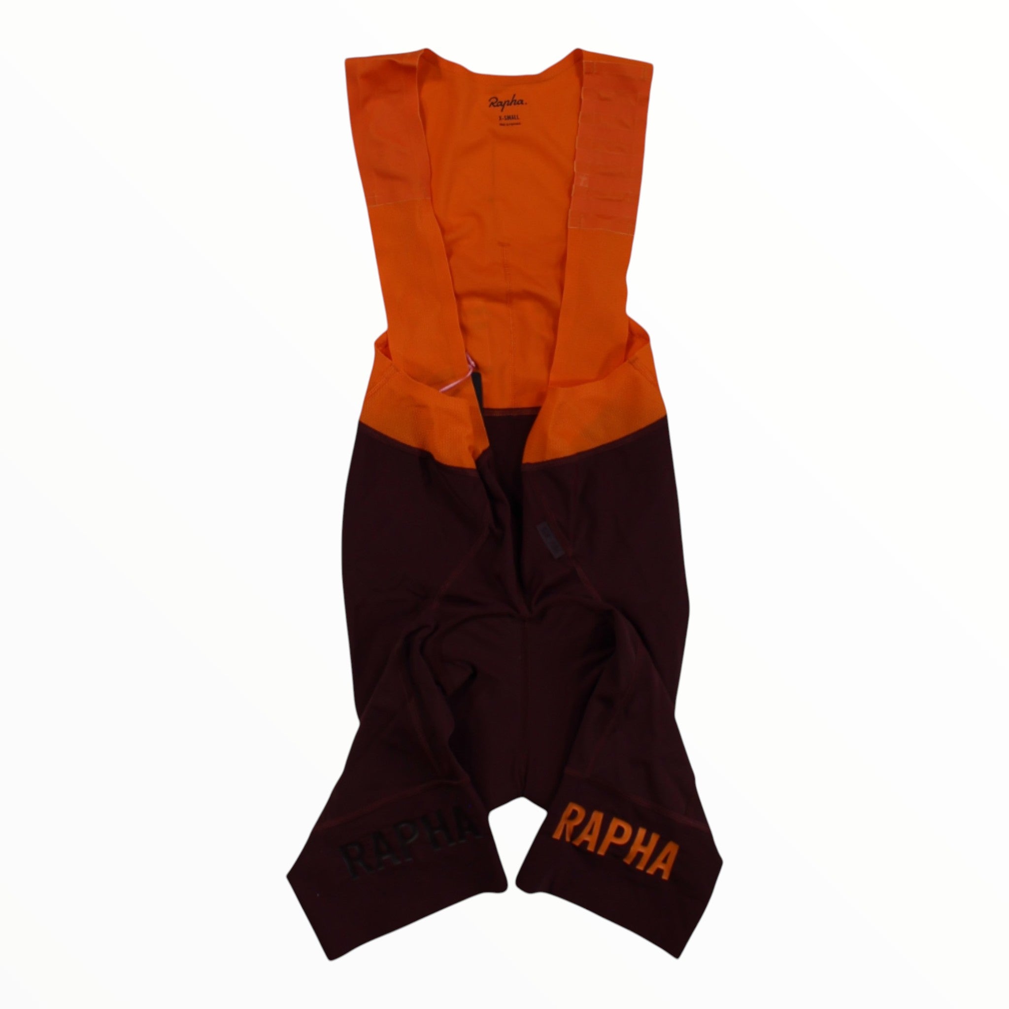 Men's Rapha bib shorts, orange upper with dark lower and Rapha logos at hems.