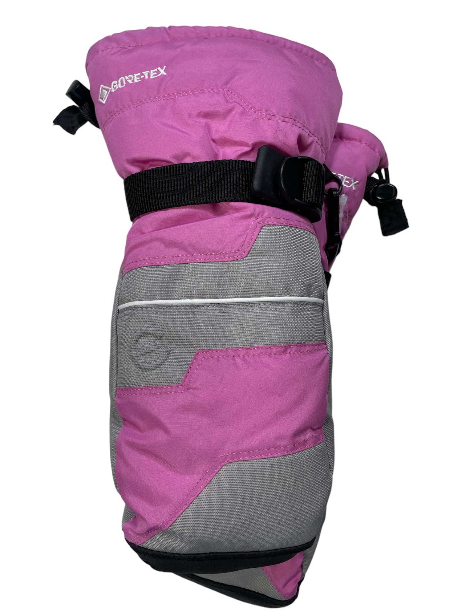 The Gordini Juniors GTX IV Mitt is a pink and gray GORE-TEX kids mitten with a black adjustable strap, reinforced for durability and waterproof protection, designed to keep hands warm in cold weather.