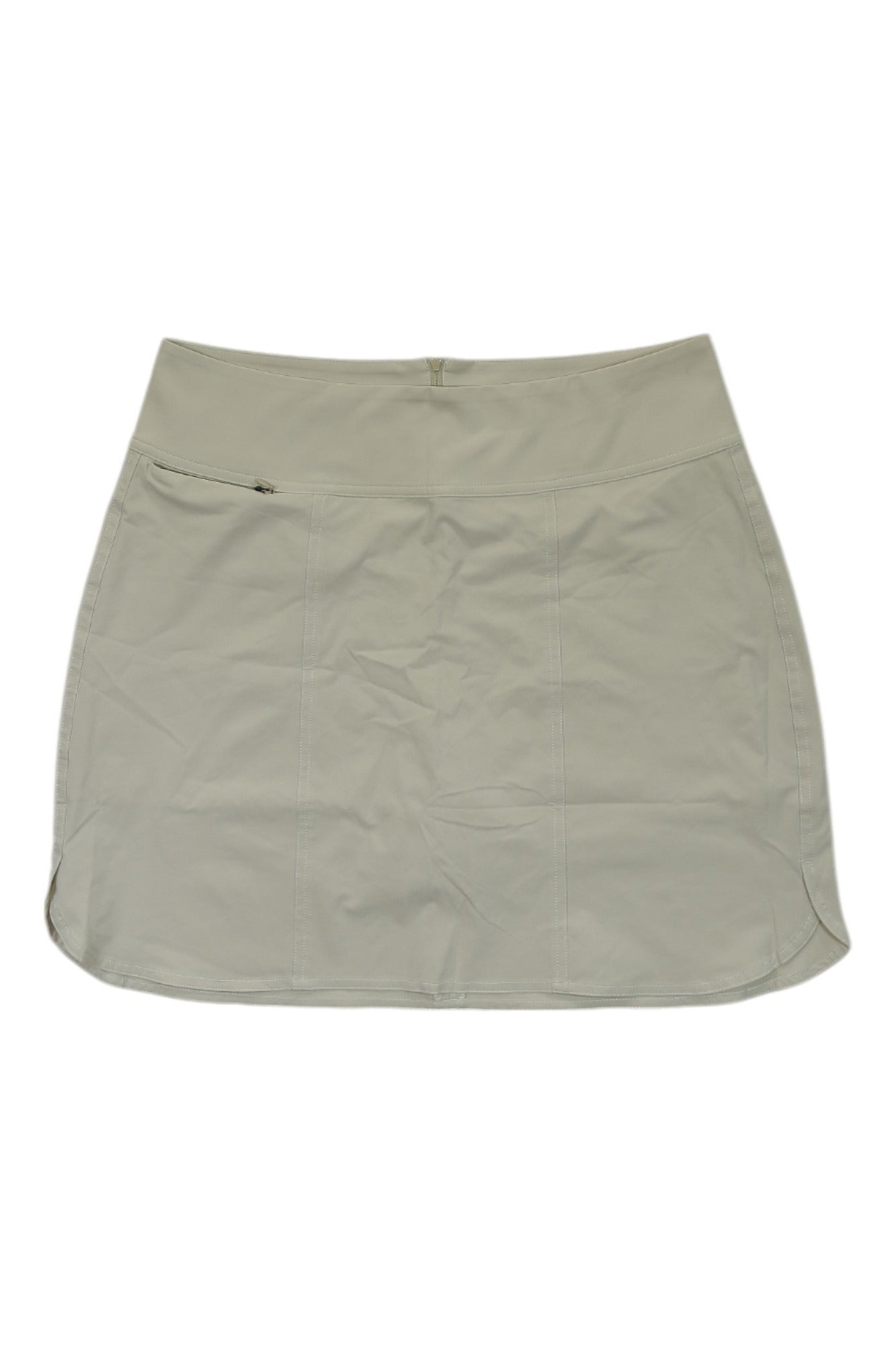 The Sherpa Womens Sajilo Skort is a light tan hiking skort featuring a left-side zipper pocket and waist zipper closure, designed for women's outdoor adventures.