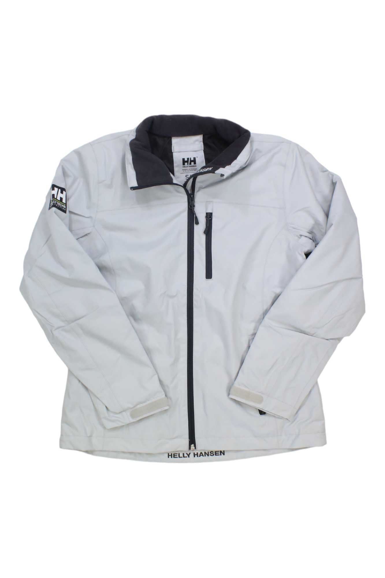 The Helly Hansen Womens Crew Midlayer Jacket is a light gray zip-front midlayer featuring a black inner collar, chest pocket, Velcro cuffs, and Helly Hansen logos on the left sleeve and inside neck.