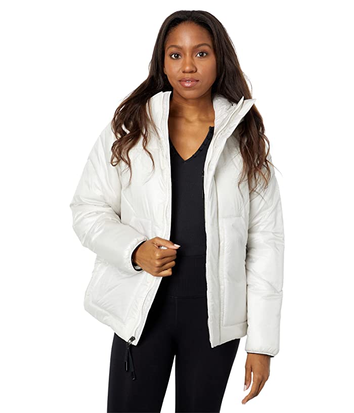 A woman in a Burton Womens Amora Puffy Jacket, black top, and black pants stands facing forward with a neutral expression against a plain white background.
