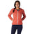 A woman faces forward, smiling with hands on hips, wearing the Smartwool Women's Merino Sport Ultra Light Hoodie in coral and dark blue pants. Her hair is in a side braid, set against a plain white background.