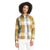 A person with curly hair wears The North Face Womens Berkeley LS Girlfriend Shirt—a yellow, blue, and white plaid, long sleeve button-front top—with white pants, standing against a plain white background.