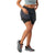 A woman in a blue sports bra, Smartwool Women's Intraknit Active Lined Short in black, and gray trail running shoes with coral laces stands with one knee slightly bent against a white background.