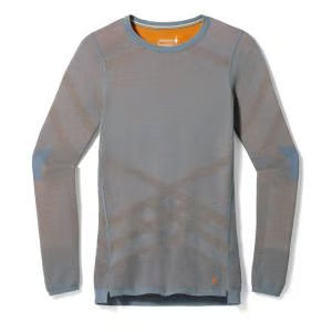 The Smartwool Women's Intraknit Thermal Merino Base Layer Crew is a seamless, long-sleeve light gray base layer featuring subtle blue details on the shoulders and cuffs with an orange inner collar for comfort and performance.