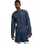 A man wears The North Face Men's Winter Warm Essential Crew in navy blue with moisture-wicking FlashDry-Pro technology and matching athletic shorts, standing against a white background and looking at the camera with one arm slightly bent.