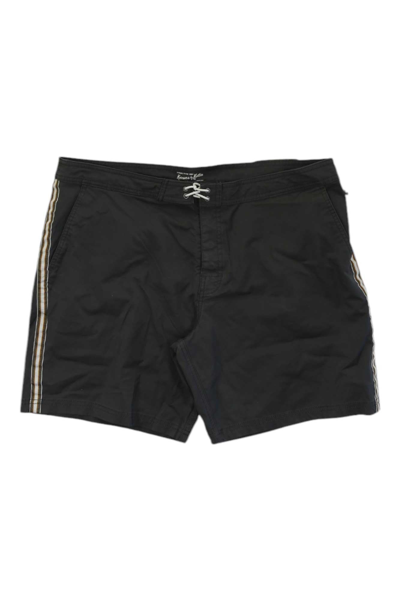 The Katin Men's Theo Trunk is a pair of black swim trunks for men with beige and white side stripes, a drawstring waistband, and made from recycled materials.