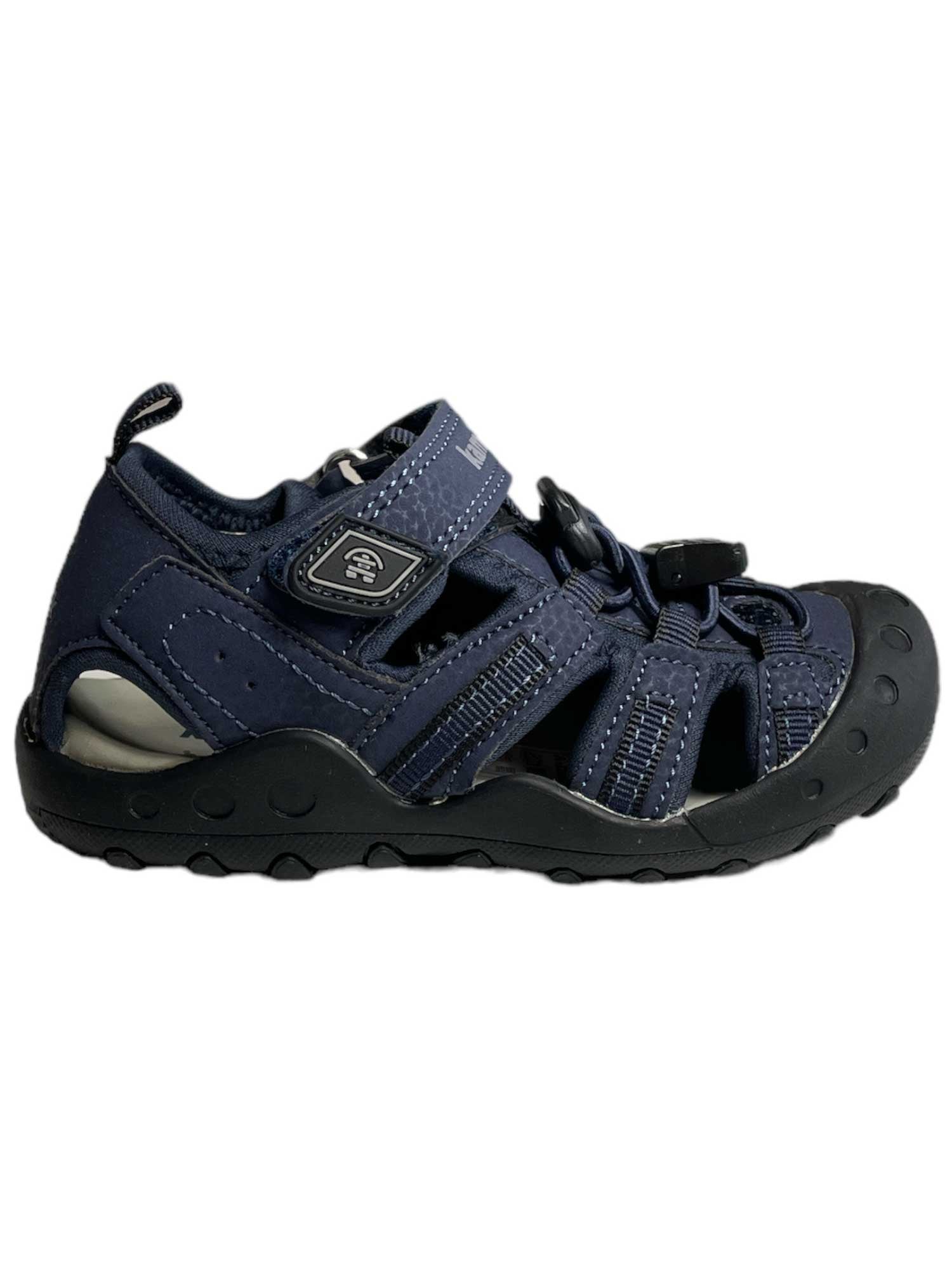 The Kamik ToddlerCrab Sandal is a navy blue closed-toe toddler sandal with a black rubber sole, protective toe cap, quick-drying cutout sides, Velcro strap, and elastic laces for an adjustable fit.