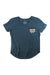 The Moosejaw Womens Peak Original Flowy V-Neck SS Pocket Tee is a blue, short-sleeved shirt made from recycled polyester and organic cotton, with a small chest pocket featuring a colorful mountain and sunset Moosejaw design.