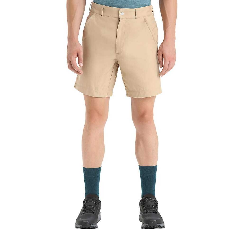 A person stands against a plain white background wearing a teal shirt, teal socks, black hiking shoes, and Icebreaker Mens Hike Short.