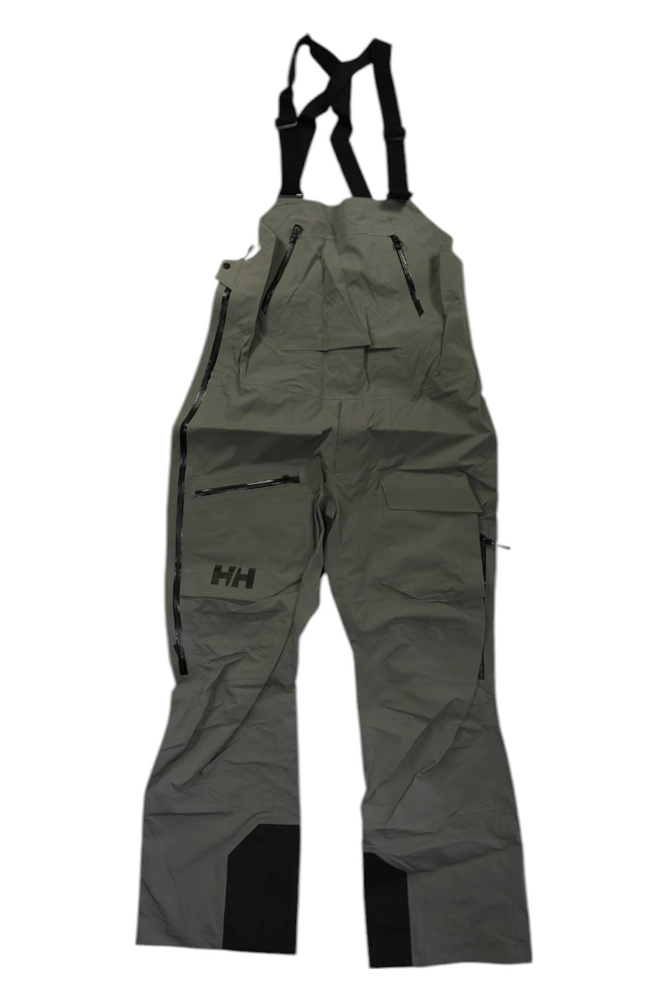 The Helly Hansen Men’s Ridge Infinity Bib Shell Pant features gray fabric, black adjustable shoulder straps, multiple zippered pockets, black reinforced knee patches, and the HH logo on the left thigh, shown against a plain white background.