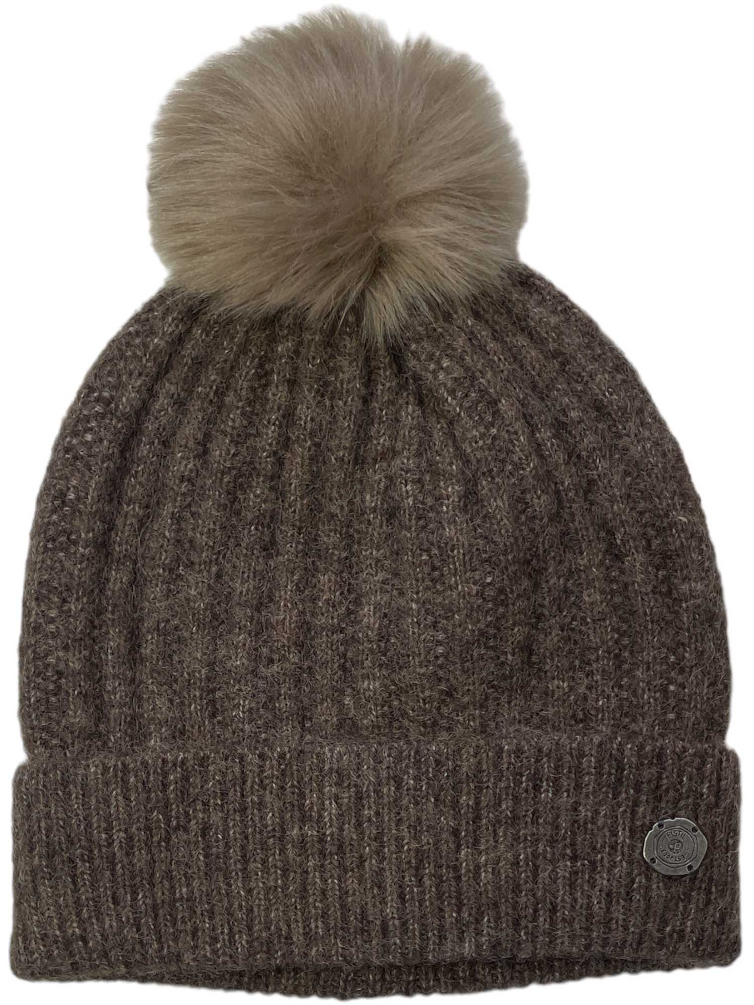 The Pistil Women's Piper Beanie is a brown ribbed knit hat with a folded brim, a large fluffy pom-pom, and a small round metal tag for added style—perfect for staying cozy in winter.