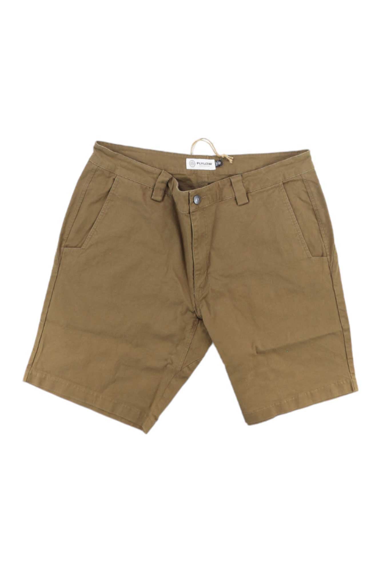 The Flylow Men's Macready 9.5 Inch Short in khaki features UPF 50+, side pockets, belt loops, and a front button and zipper closure, shown laid flat on a white background.