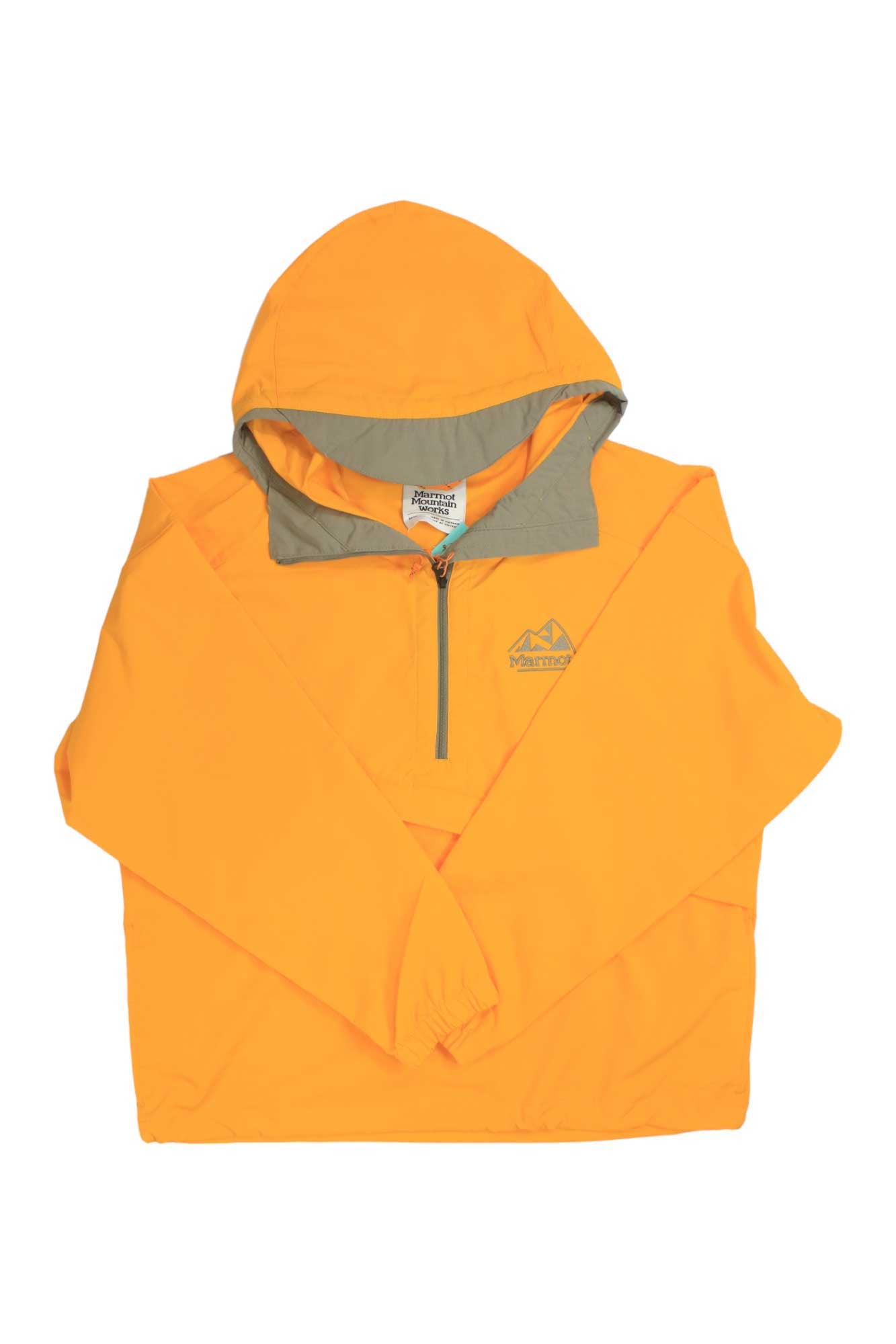 The Marmot Womens 96 Active Anorak is a bright orange pullover jacket featuring a front half-zip, light brown inner hood lining, small chest logo, and is made from recycled polyester. Displayed against a white background.